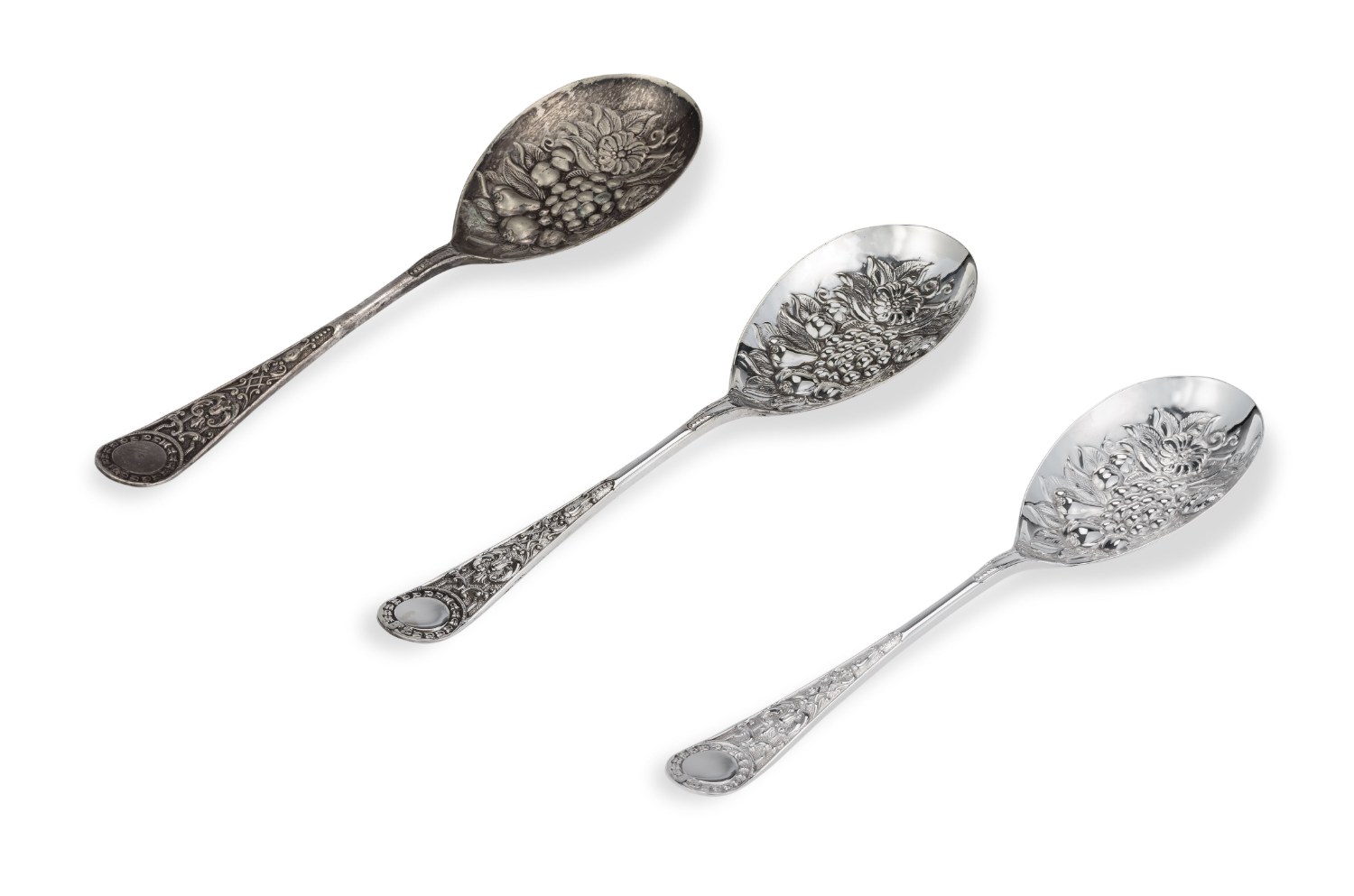 Three ornate berry spoons — one tarnished before re-plating, two brightly restored after
