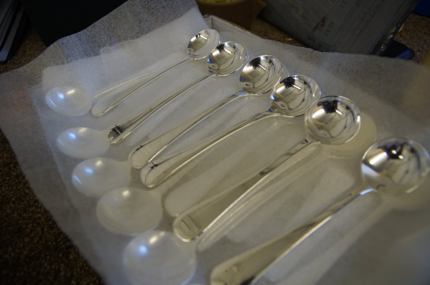 Freshly re-plated soup spoons laid out on packing foam, ready to return